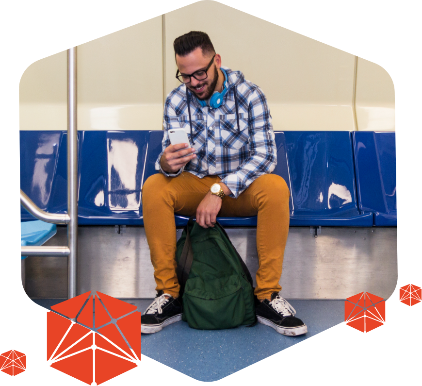 Homem sentado no banco do metrô com fones de ouvido e olhando tela de smartphone